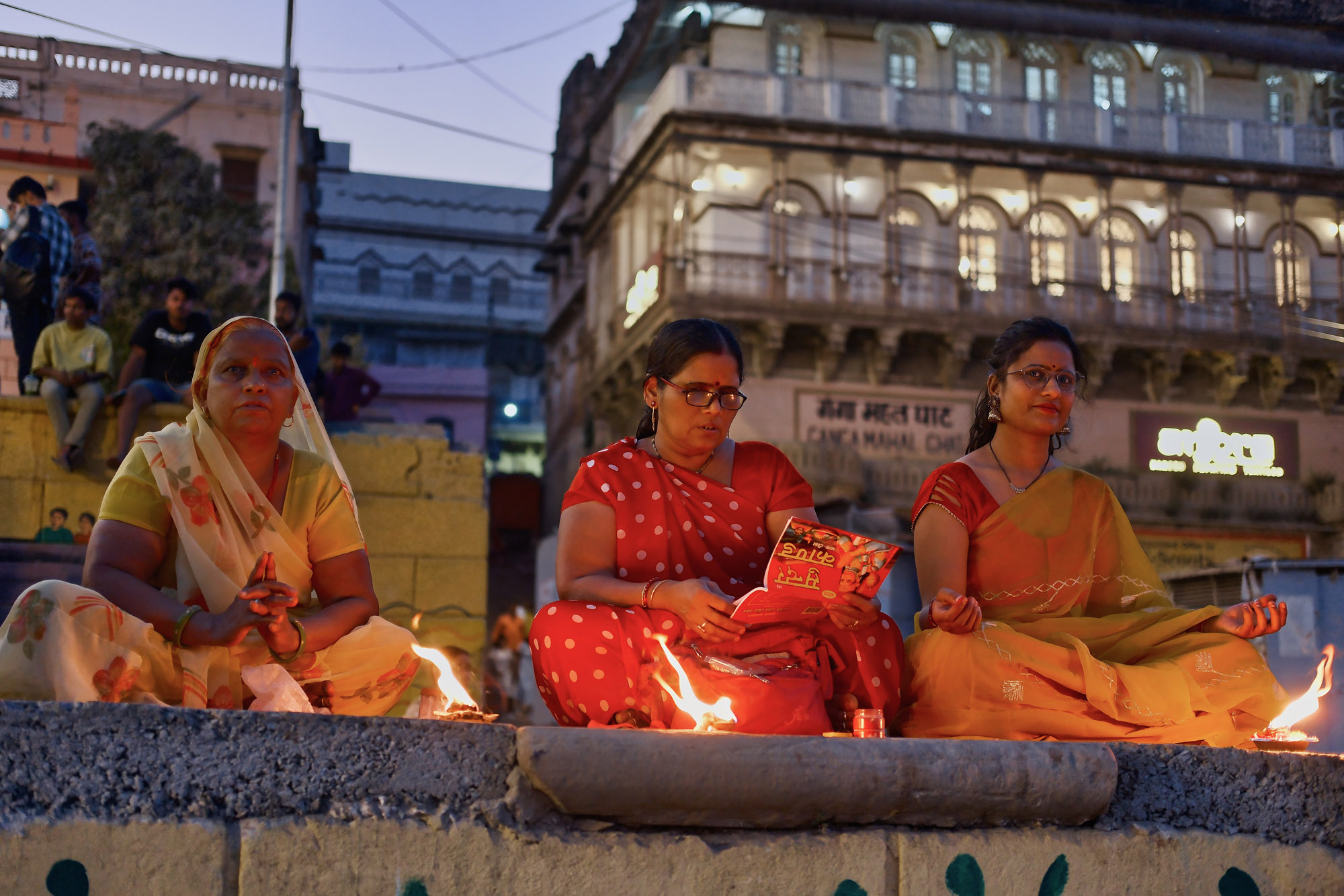 Donne in preghiera con i lumini al Ganga Mahal Ghat, Varanasi, Uttar Pradesh, India
