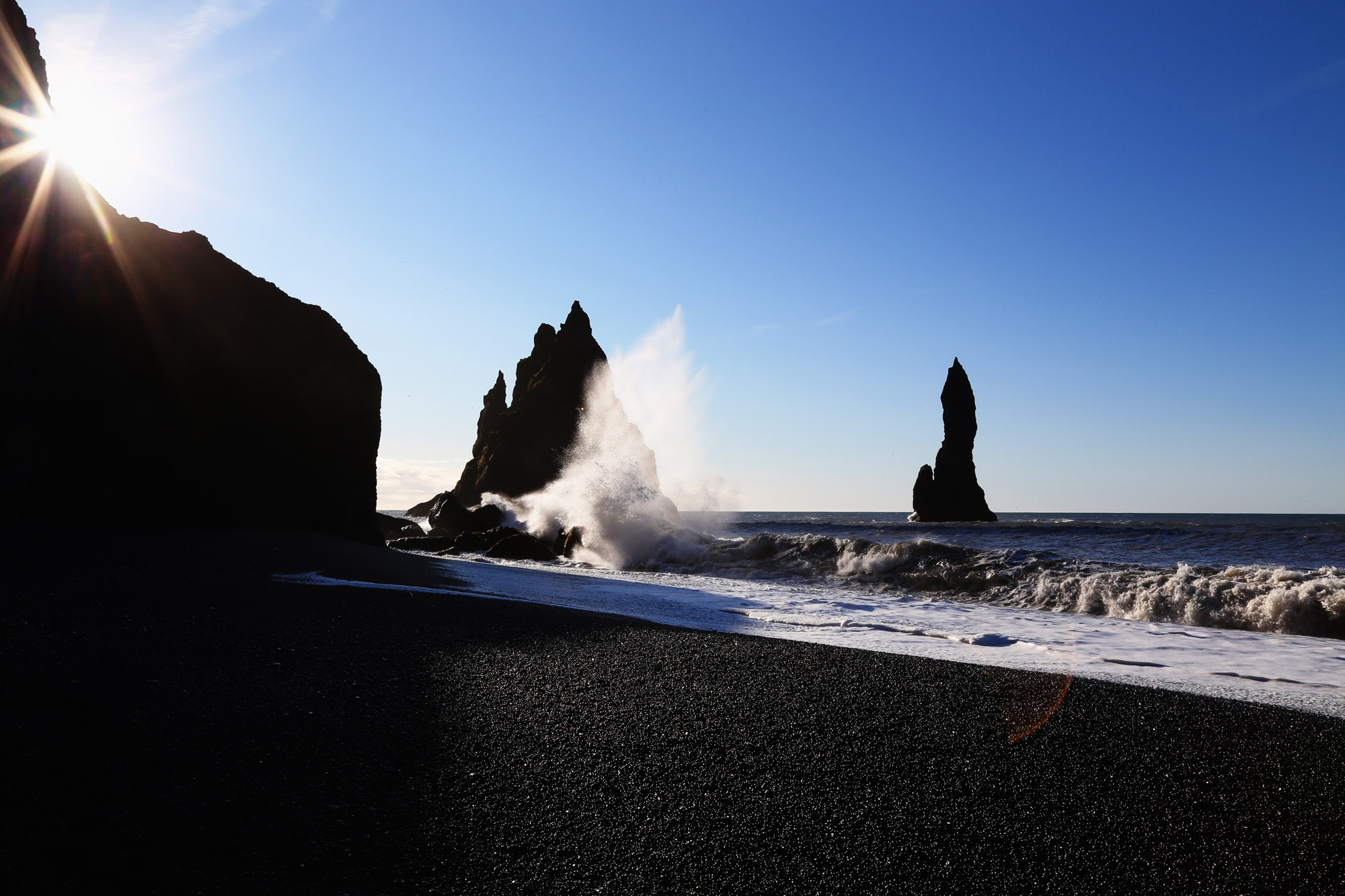 Faraglioni di basalto e onde sulla spiaggia nera di Reynisfjara
