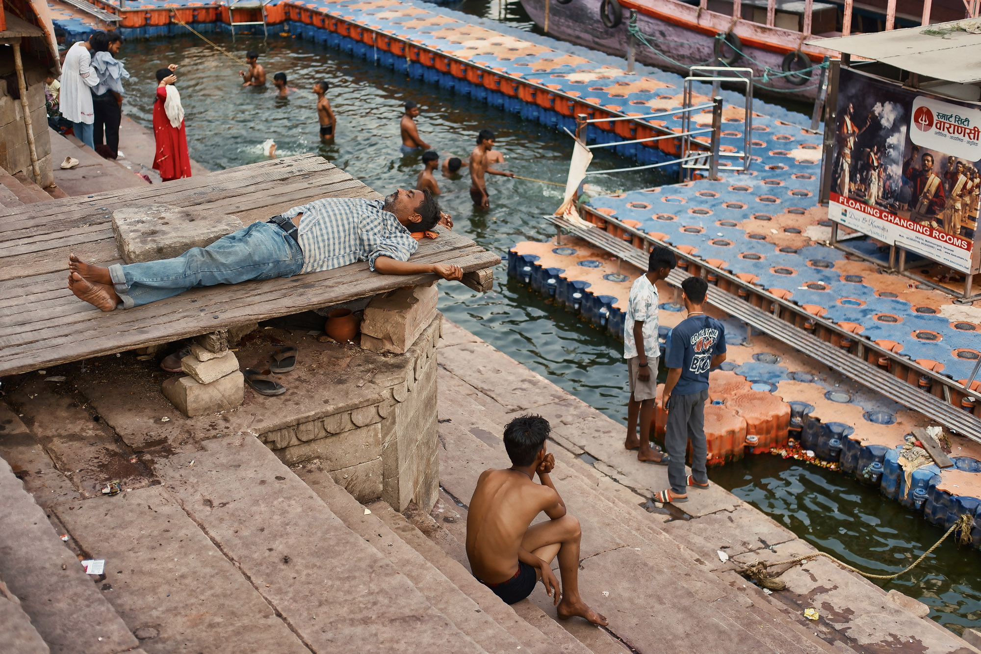 Bagnanti e cabine galleggianti sul Gange dai ghat di Varanasi, Uttar Pradesh, India