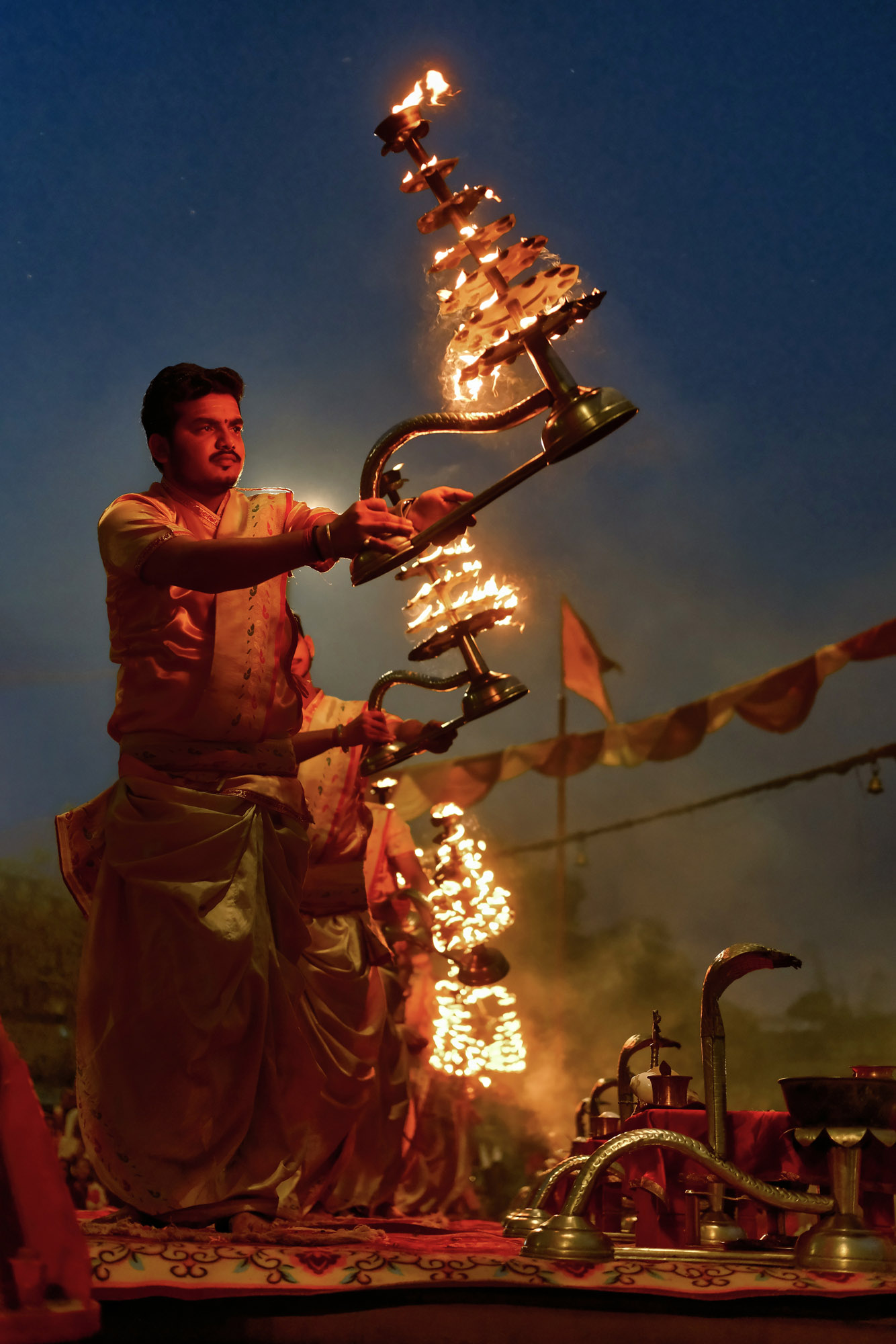 Sacerdote con la lampada di fuoco durante il Ganga Aarti, Varanasi, Uttar Pradesh, India